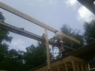 Carpenter setting a ridge beam over a new addition frame — Ice Dam Removal by Roofing Brothers in Dyer
