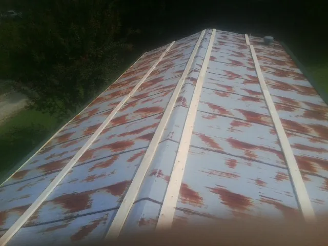 Rusted metal roof panels with new wood purlins before replacement — Storm Damage Roof Repair in Dyer by Roofing Brothers