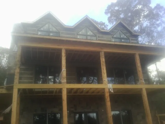 Dormers and porch framing on a large log home under construction — Roof Coating work by our crew in Dyer