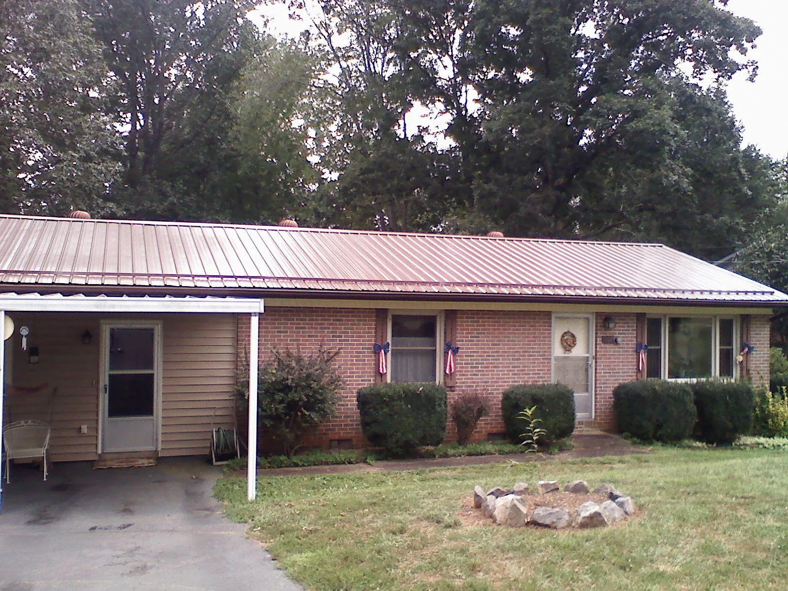 Bronze metal roof and carport on a brick ranch home — Roof Repair work by our crew in Dyer